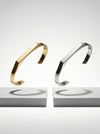 Gold and silver bangle bracelets on a light gray background