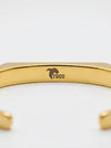Gold bracelet with 'Tucc' branding on a white background