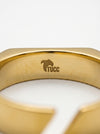 Gold ring with 'TUCC' branding on a white background