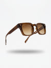 Brown sunglasses with gradient lenses on a light gray background
