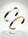 Gold and silver bangles on a light gray background