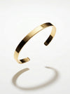 Gold bracelet on a light gray background