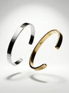 Gold and silver bangles on a light gray background