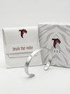 Silver bangle with branded packaging on a white background