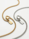 Two gold and silver chain necklaces with 'Tucc' tags on a white background