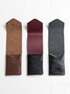 Three leather phone cases in brown, red, and black on a white background