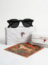 Black sunglasses on a white box with a tiger design, surrounded by branded items.