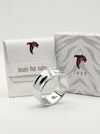 Silver ring with Tucc branding on a white background