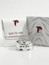 Silver ring with Tucc packaging on a white background
