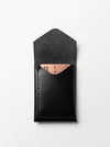 Black leather cardholder with rose gold accent on a white background