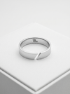Silver ring with a unique design on a light gray background