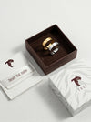 Two rings in a brown box with Tucc branding on a light gray background
